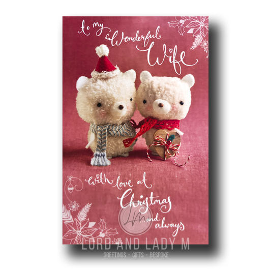 Front of Christmas card showing two plush pompom bears on a pinky red background; one bear wears a Santa hat and stripey scarf, the other holds a gift in a red scarf; text reads “To my Wonderful Wife with love at Christmas and always.